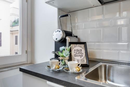 eine Küchentheke mit zwei Tassen Kaffee drauf in der Unterkunft Klioos Apartment Testaccio in Rom
