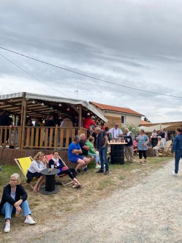 a group of people sitting in chairs under a tent at Camping de la ferme aux ânesses, mobil home sofia2 in Bressuire