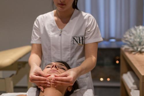 a woman receiving a massage from a therapist at Hotel Alexander in Cattolica