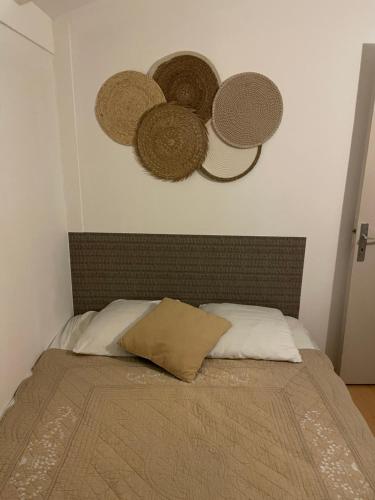 ein Bett mit drei Hüten an der Wand in der Unterkunft Villa de Carbonelle in Pierrevert