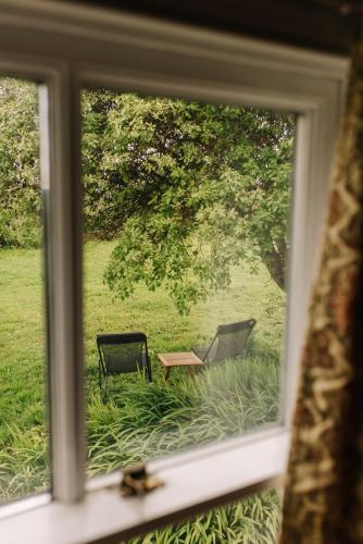 a window view of a chair and a table at Kitts Cottage, Redruth, Cosy Cornish Retreat in Redruth