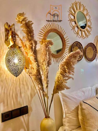 a vase with dried flowers in a room with mirrors at Riad Sahara Stars Dades in Boumalne
