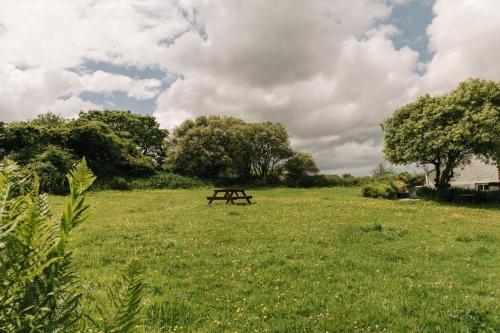 a picnic table in the middle of a field at Kitts Cottage, Redruth, Cosy Cornish Retreat in Redruth