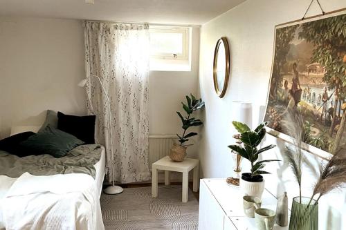 a bedroom with a bed and a table with plants at Limhamn city-ocean in Limhamn