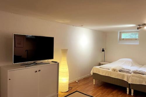 a bedroom with a flat screen tv on top of a bed at Limhamn city-ocean in Limhamn