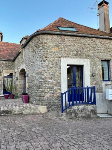 a brick building with a blue gate in front of it at Hôtel du Commerce in Semur-en-Auxois