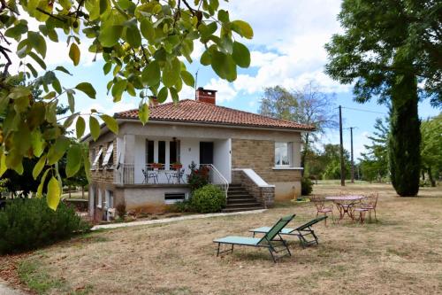 een huis met drie picknicktafels ervoor bij Le Gîte de Lardois in Miers