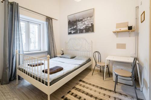 een slaapkamer met een bed, een bureau en een tafel bij Laykonik in Krakau