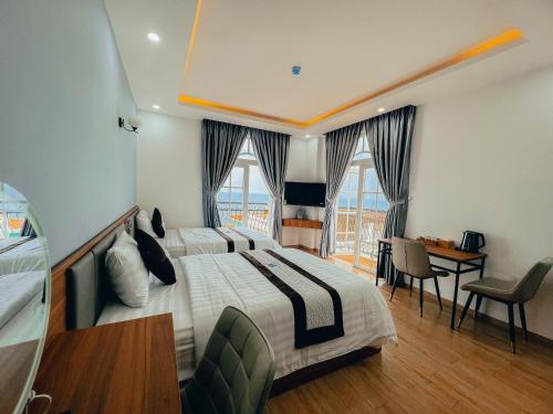 a hotel room with a large bed and a desk at Labe Hotel Phú Quốc - Sunset Town - Địa Trung Hải in Phú Quốc