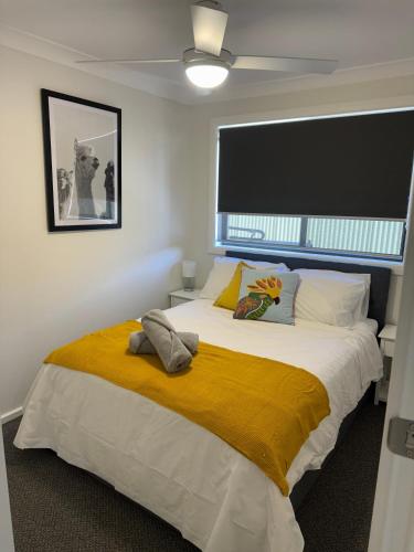 a bedroom with a large bed with a yellow blanket at Central Evans Wagga Apartments in Wagga Wagga