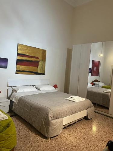 TrepuzziにあるSalento b&b Trepuzziのベッドルーム1室(ベッド1台付)が備わります。壁には絵画が飾られています。
