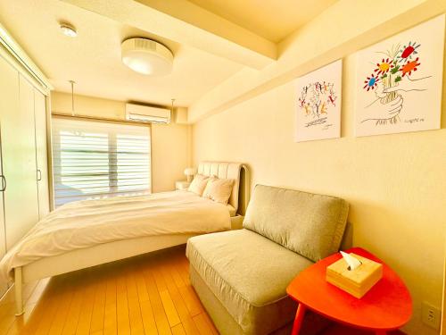 1 dormitorio con cama, sofá y mesa en Cube Stay 北東京, en Tokio