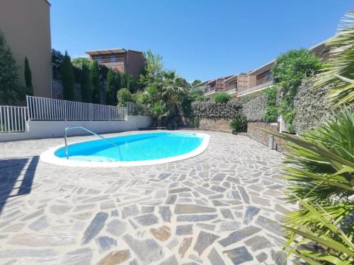 una piscina en medio de un patio en Appartement T3 avec piscine, climatisation, wifi et garage, en Collioure