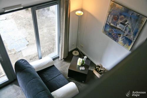 sala de estar con sofá y ventana grande en Les Braises de la Semois, en Florenville