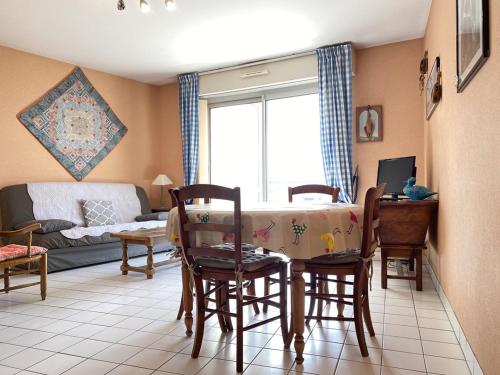 un salon avec une table, des chaises et un canapé dans l'établissement 511 - A Erquy, en bordure de la plage du centre et à 300m du centre des commerces, à Erquy