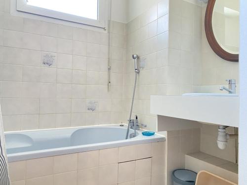 une salle de bain blanche avec une baignoire et un lavabo dans l'établissement 511 - A Erquy, en bordure de la plage du centre et à 300m du centre des commerces, à Erquy