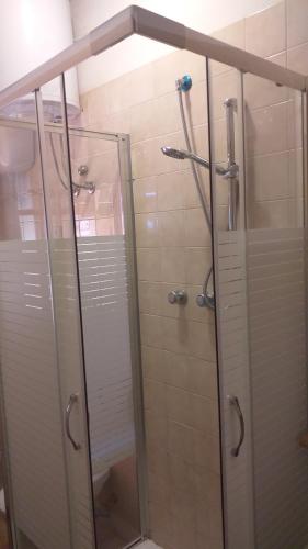 y baño con ducha y puerta de cristal. en Villa Solanas, en Solanas