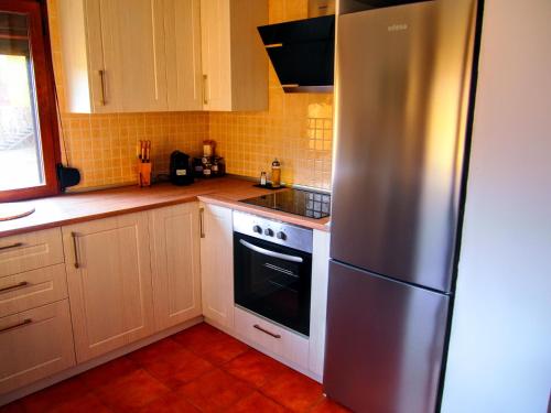 a kitchen with a stainless steel refrigerator and white cabinets at Alojamiento Rural Los Hacheros in Tragacete