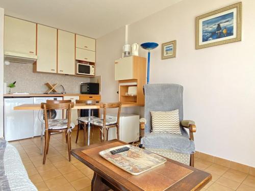 un salon avec une table et une cuisine dans l'établissement 512 - A Erquy, en bordure de la plage du centre, à 300m du centre des commerces, à Erquy