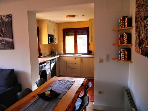 a kitchen with a wooden table and a dining room at Alojamiento Rural Los Hacheros in Tragacete