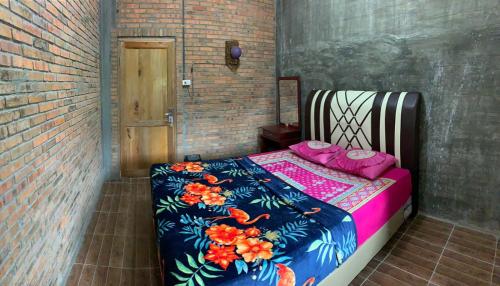 una camera da letto con un letto con un piumone colorato di bungalow karohill a Berastagi