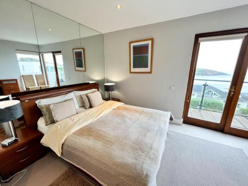 a bedroom with a large bed with a large window at Sea Haven - My Tranquil Costal Retreat - Commanding Views in Youghal