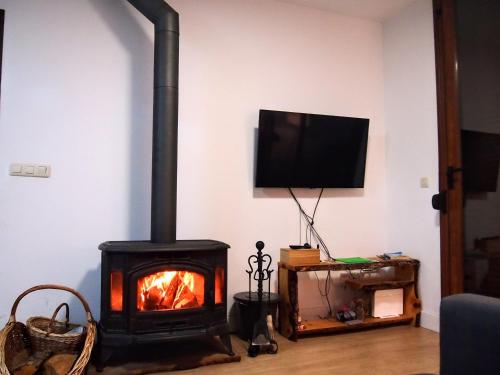 a fireplace in a living room with a tv at Alojamiento Rural Los Hacheros in Tragacete