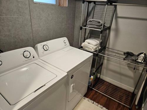 ein Badezimmer mit einer Waschmaschine und einem Regal mit Handtüchern in der Unterkunft Cozy 2 bedroom West Fargo home with 2 car garage in West Fargo