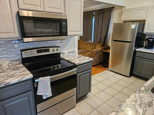a kitchen with a stove and a stainless steel refrigerator at Cozy 2 bedroom West Fargo home with 2 car garage in West Fargo