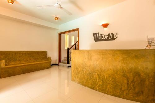 a lobby with a couch and a sign on the wall at Royal Villa in Weligama