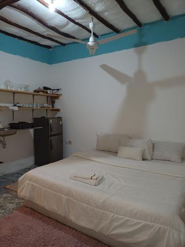 1 dormitorio con 1 cama blanca grande con sombra en la pared en Moha Airbnb Diani en Ukunda