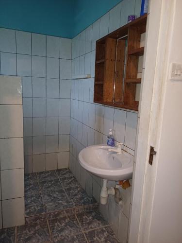 y baño con lavabo y espejo. en Moha Airbnb Diani en Ukunda