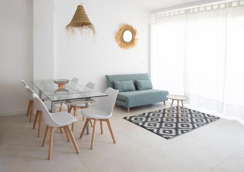 ein Wohnzimmer mit Tisch und Stühlen und einer Couch in der Unterkunft Nuevo apartamento planta baja in Bellreguart
