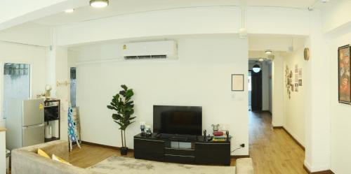 a living room with a tv and a couch at Hidden Gems in China town, 2BR in Bangkok