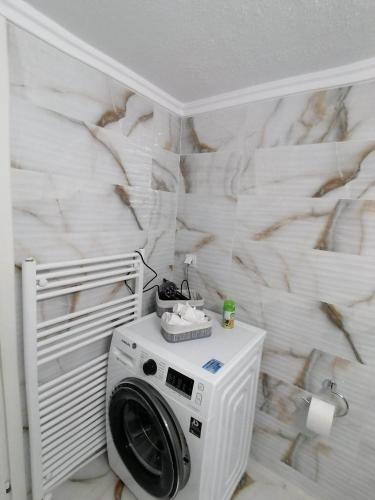 a washing machine in a bathroom with a wall at DZ Apartment AXD in Alexandroupoli