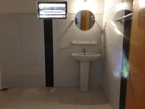 a bathroom with a sink and a mirror at Gems Garden Guest House in Tangalle