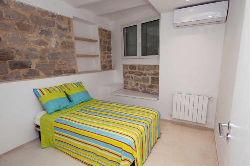 um quarto com uma cama com um cobertor listrado colorido em "L'Abri Côtier" Appartement 3 chambres Haut Standing Port Punique Carthage em Douar ech Chott