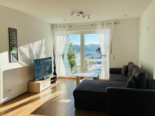 een woonkamer met een bank en een flatscreen-tv bij Schmid's Ponyhöfle in Friedrichshafen