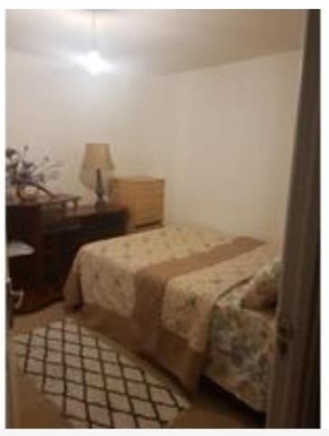 a bedroom with a bed and a table with a lamp at Residential property in Edmonton