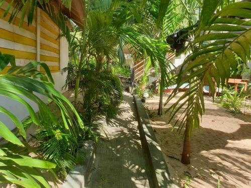 a group of palm trees in front of a house at Gems Garden Guest House in Tangalle