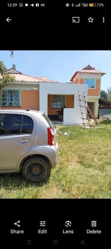 una foto de un coche aparcado frente a una casa en Home away from Home en Kisii