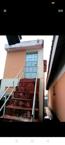 a set of stairs leading to a building with a blue door at Home away from Home in Kisii