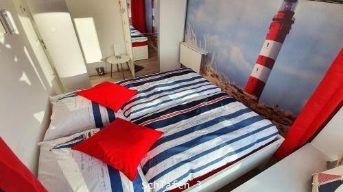 een slaapkamer met een bed met rode kussens bij TRAUM FeWo Strandliebe mit Meerblick, 3 Schlafzimmer, 2 Bäder in Binz
