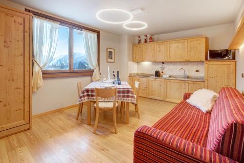 una cucina e una sala da pranzo con tavolo e sedie di Chalet Meridiana a Bormio