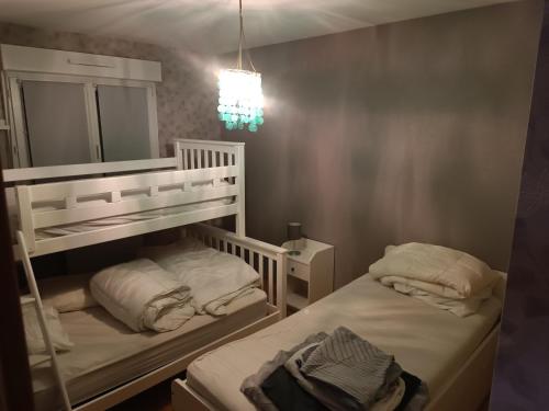 a bedroom with two bunk beds and a mirror at Le plein soleil in Cornimont