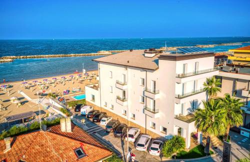 eine Luftansicht auf ein Gebäude und einen Strand in der Unterkunft You & Me Beach Hotel in Rimini