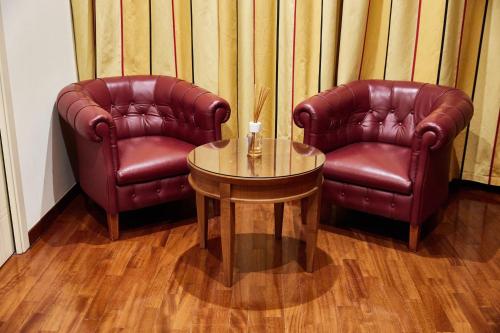 two leather chairs and a table in a room at Appia Antica Hotel in Corato