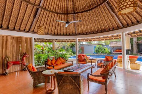 una sala de estar al aire libre con un gran techo de mimbre en Bali Akasa Villa en Seminyak