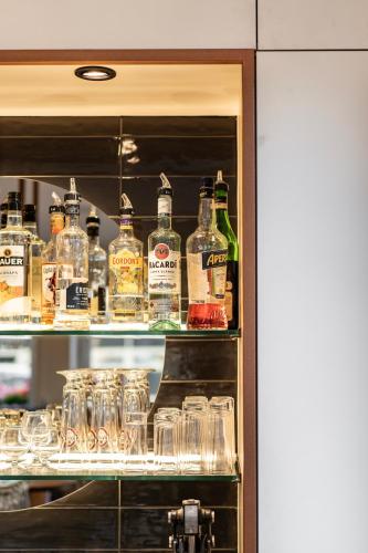 a shelf filled with glasses and bottles of alcohol at Hotel Lokomotive in Linz