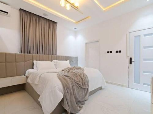 sypialnia z dużym łóżkiem i białymi ścianami w obiekcie luxury studio apartment w mieście Lekki